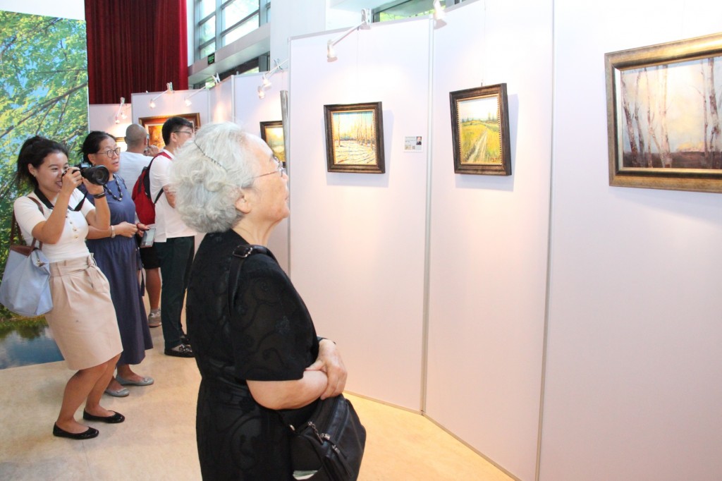 Посетители осматривают картины российских и китайских художников 