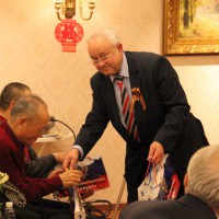Виктор Коннов вручает ветеранам памятные подарки / 维克多.孔诺夫向老战士赠送纪念礼品