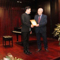 Директор РКЦ в Пекине Виктор Коннов вручает благодарность пианисту